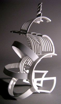 a sculpture made out of metal on a gray surface with black and white lines in the middle