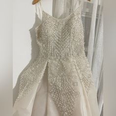 a dress hanging on a hanger in front of a window