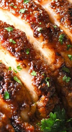 closeup of sliced meat with parsley on top and seasoning around the edges