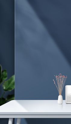 a white table with a plant on it next to an air purifier