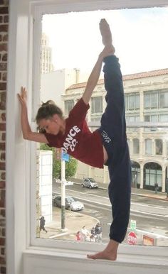 a man doing a handstand on a window sill