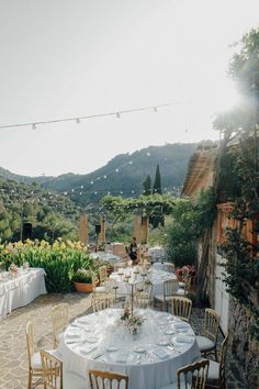 an outdoor dining area with tables and chairs set up for a formal function in the mountains