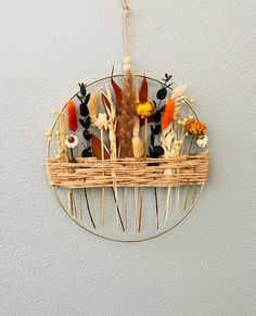 a basket with flowers and feathers hanging on the wall