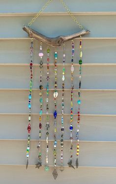 a wind chime hanging on the side of a building with beads and charms attached to it