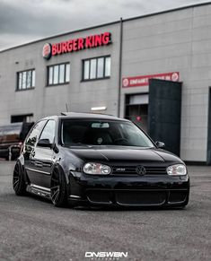 a black car parked in front of a burger king