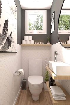 a white toilet sitting in a bathroom next to a sink and mirror on a wall