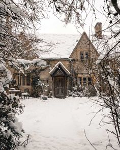 a house is covered in snow and surrounded by trees