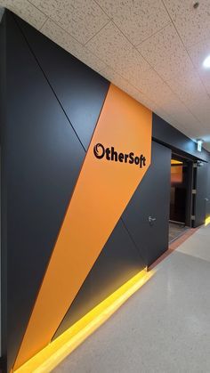 there is a sign that says othersoft on the wall in an office building with orange and black accents