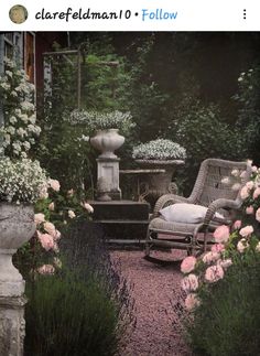 a chair and table in a garden surrounded by flowers