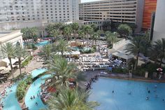 an aerial view of a hotel pool and surrounding area with palm trees in the foreground