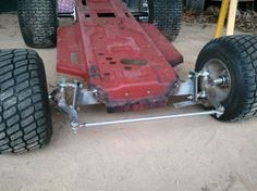 a red race car sitting on top of a parking lot