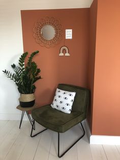 a green chair sitting next to a potted plant