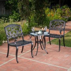 an outdoor table and two chairs on a brick patio