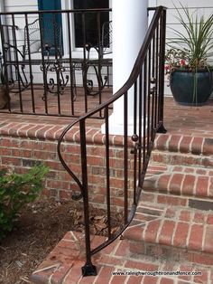 an iron hand rail on the front steps of a house