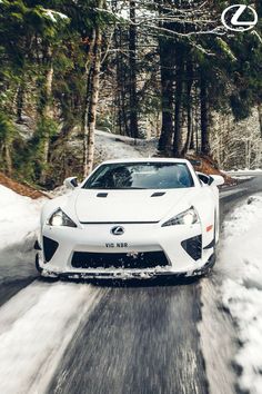 a white car driving down a snow covered road