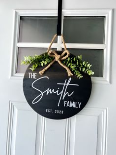 the smith family sign hanging on a door with rope and plants in front of it