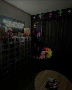 a room with black walls and colorful teddy bears on the wall in front of it