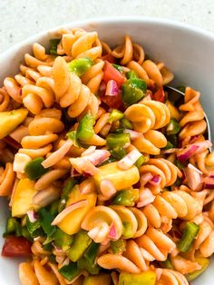 a white bowl filled with pasta salad on top of a table