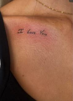 the back of a woman's shoulder that says i love you in cursive writing