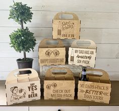 several wooden boxes with different types of beer on top of a table next to a potted plant