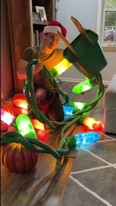 a man sitting on the floor next to christmas lights