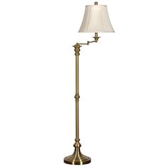 a floor lamp with a white shade on the base and a gold metal finish to it