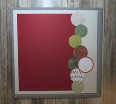 a red and green painting hanging on a wall next to a wooden door with a metal frame