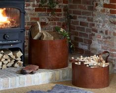 a fire place sitting next to a pile of logs