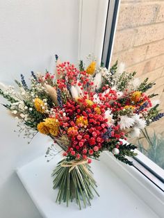 a bouquet of flowers sitting on top of a window sill