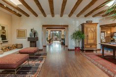 a living room filled with furniture and a wooden floor covered in lots of rugs