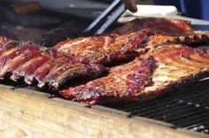 steaks being grilled on the grill with tongs