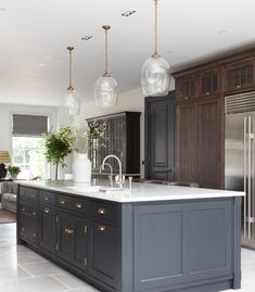 a large kitchen with an island in the middle and lots of cabinets on both sides