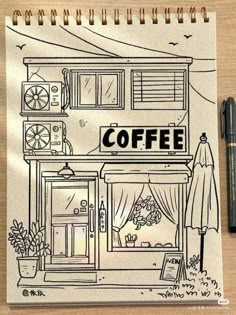 a drawing of a coffee shop on a piece of paper with a pen next to it