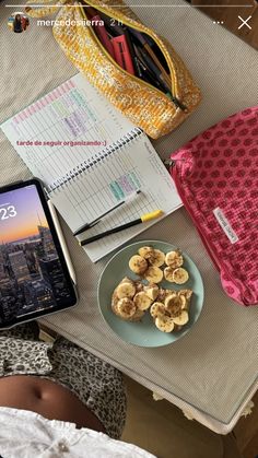 a table topped with a plate of food next to a cell phone and laptop computer