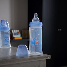 two baby bottles sitting on top of a table