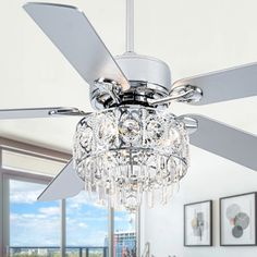 a ceiling fan with crystal chandelier hanging from it's blades in a living room