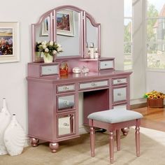 a pink vanity with mirror and stool in a room