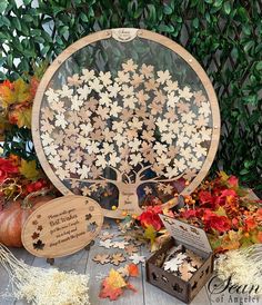 a wooden tree with leaves on it surrounded by other autumn decorations