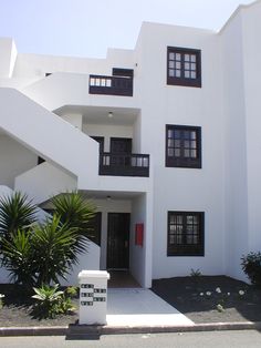 a white building with black windows and balconies