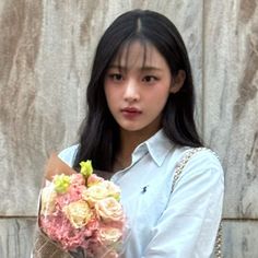 a young woman holding a bouquet of flowers