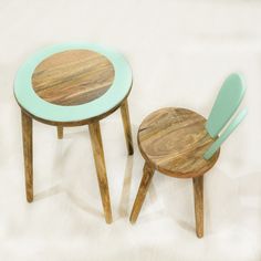 two small wooden chairs and table on a white surface