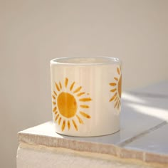 a coffee cup sitting on top of a table next to a white wall and floor