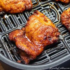 several pieces of chicken cooking on a grill