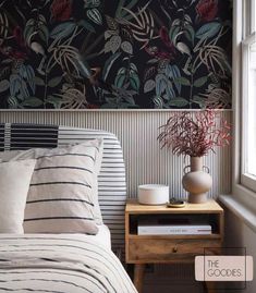 a bed sitting next to a window in a room with a plant on top of it