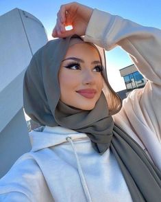 a woman wearing a hijab poses for the camera