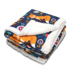 two blankets folded on top of each other with an orange fox and flower pattern in the middle