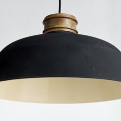 a black and white pendant light hanging from a ceiling fixture with wood accents on it