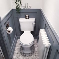 a bathroom with a toilet, radiator and towel rack in the corner next to it