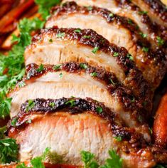 sliced pork on a plate with carrots and parsley