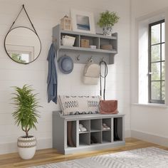 a room with a bench, potted plant and other items on the wall above it